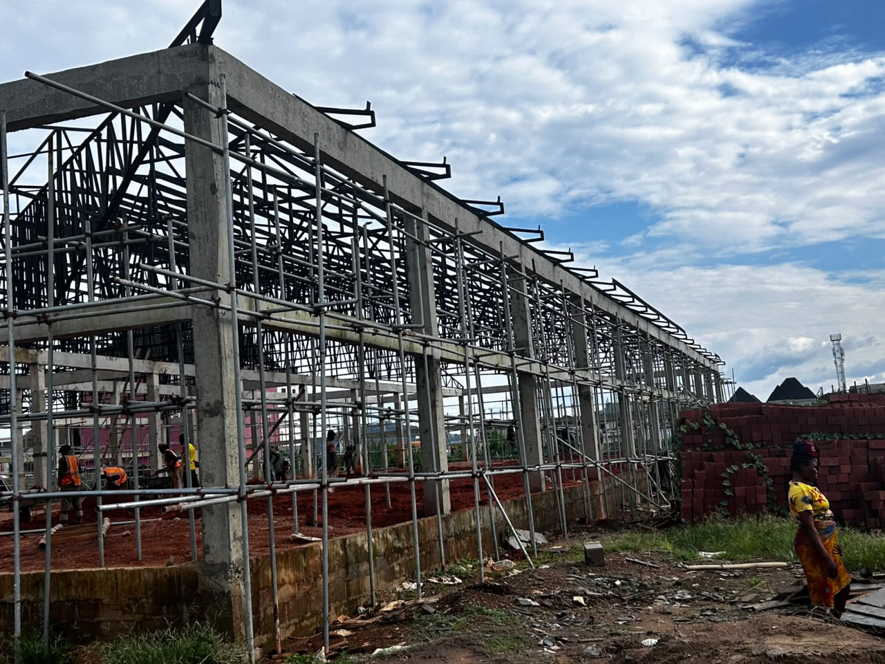 Concrete building structure under construction with scaffolding and site crane